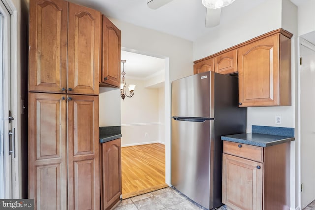 19918 Wyman Way, Germantown, MD 20874 - kitchen featuring freestanding refrigerator, dark countertops, crown molding, brown cabinetry, and a ceiling fan