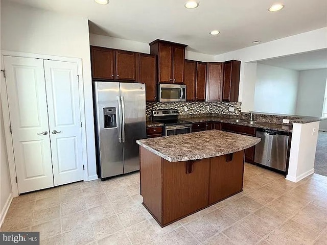 4118 Votive, Williamsburg, VA 23188 - kitchen with appliances with stainless steel finishes, a sink, a center island, backsplash, and dark brown cabinets