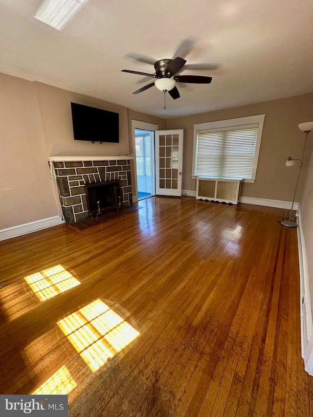 647 Aronimink Pl, Drexel Hill, PA 19026 - unfurnished living room with radiator, ceiling fan, a stone fireplace, and wood finished floors