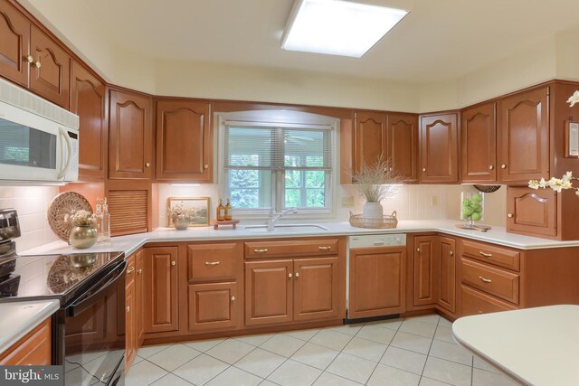 7 Brookside Cir, Myerstown, PA 17067 - kitchen featuring black / electric stove, dishwashing machine, white microwave, a sink, and backsplash