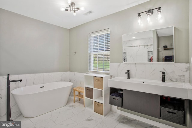 3270 Channel Ct, Huntingtown, MD 20639 - bathroom featuring tile walls, a soaking tub, marble look tiles, vanity, and wainscoting