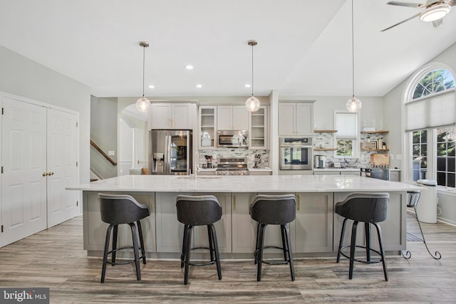 3270 Channel Ct, Huntingtown, MD 20639 - kitchen featuring stainless steel appliances, light wood-style flooring, backsplash, a spacious island, and glass insert cabinets