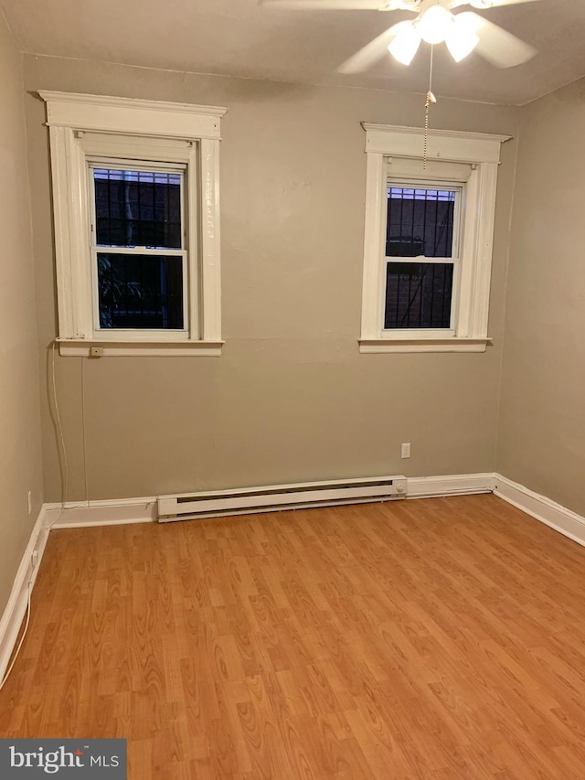 4621 N Broad St, Philadelphia, PA 19140 - spare room with ceiling fan, wood finished floors, a baseboard heating unit, and baseboards