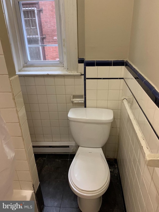 4621 N Broad St, Philadelphia, PA 19140 - bathroom featuring a baseboard radiator, tile walls, toilet, a wainscoted wall, and tile patterned flooring
