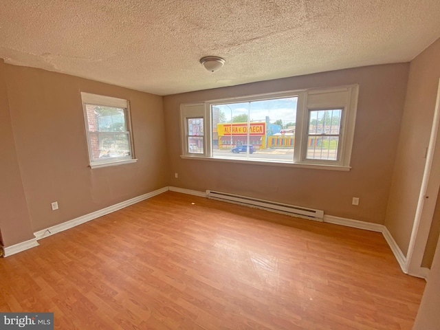 4621 N Broad St, Philadelphia, PA 19140 - spare room with baseboard heating, light wood-style flooring, a textured ceiling, and baseboards