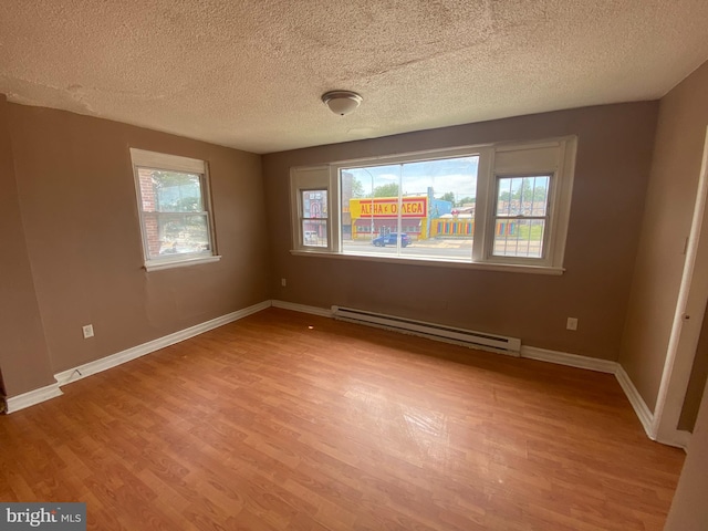 4621 N Broad St, Philadelphia, PA 19140 - unfurnished room with baseboard heating, light wood finished floors, a textured ceiling, and baseboards