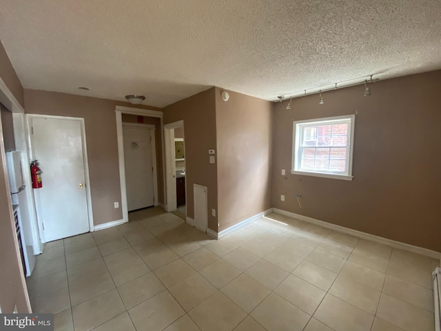 4621 N Broad St, Philadelphia, PA 19140 - spare room featuring a textured ceiling, light tile patterned flooring, and baseboards