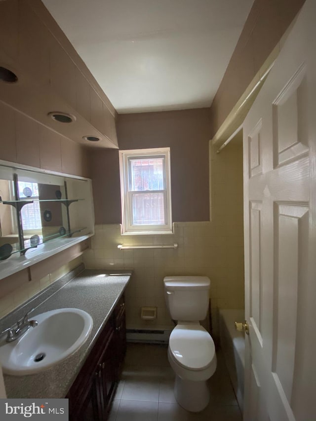 4621 N Broad St, Philadelphia, PA 19140 - full bath featuring tile walls, tile patterned floors, a baseboard radiator, vanity, and toilet
