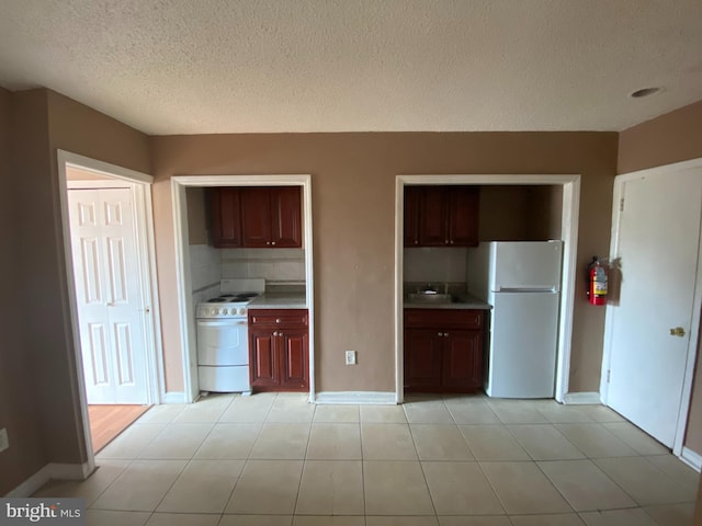 4621 N Broad St, Philadelphia, PA 19140 - kitchen featuring white appliances, baseboards, light countertops, a sink, and a textured ceiling