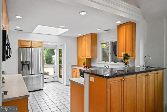 1414 N Johnson St, Arlington, VA 22201 - kitchen featuring stainless steel fridge, a skylight, a peninsula, a sink, and light tile patterned floors