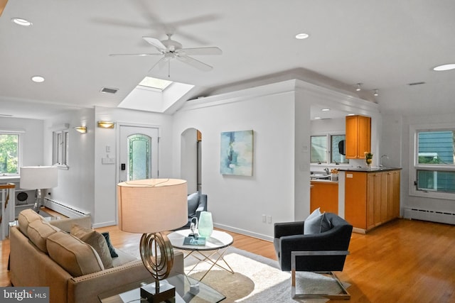 1414 N Johnson St, Arlington, VA 22201 - living room featuring a skylight, a ceiling fan, light wood-style floors, baseboard heating, and lofted ceiling