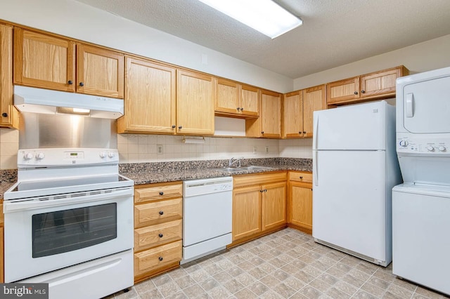 15115 Interlachen Dr Unit 3-920, Silver Spring, MD 20906 - kitchen with white appliances, stacked washer and clothes dryer, under cabinet range hood, a sink, and backsplash