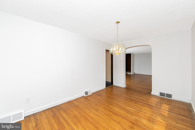 681 Dutton Cir, Springfield, PA 19064 - empty room with a chandelier, arched walkways, light wood finished floors, and baseboards