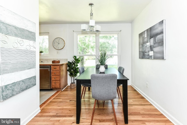 6322 Phyllis Ln, Alexandria, VA 22312 - dining area featuring light wood finished floors, a chandelier, baseboards, and a wall unit AC