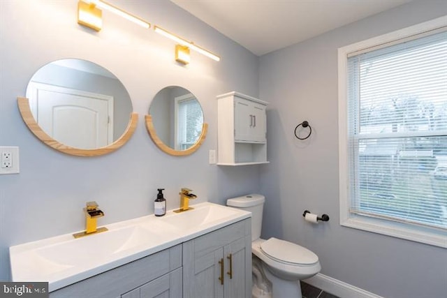 2306 Monticello Rd, Baltimore, MD 21216 - bathroom featuring double vanity, toilet, and baseboards