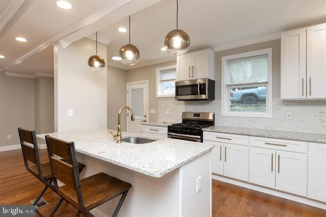 2306 Monticello Rd, Baltimore, MD 21216 - kitchen featuring gas stove, stainless steel microwave, a sink, crown molding, and dark wood-style flooring