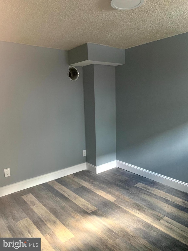 4103 Grace Ct, Baltimore City, MD 21226 - empty room with dark wood-style floors, a textured ceiling, and baseboards