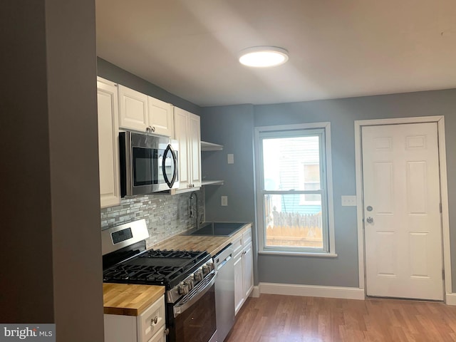 4103 Grace Ct, Baltimore City, MD 21226 - kitchen with appliances with stainless steel finishes, wood counters, backsplash, light wood finished floors, and baseboards