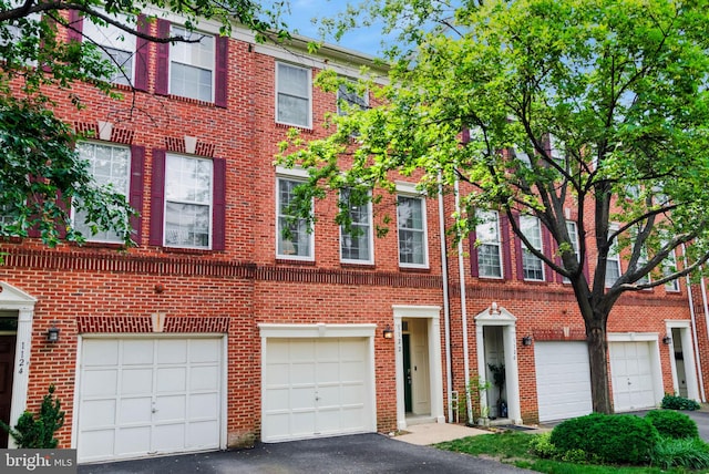 1122 S Monroe St, Arlington, VA 22204 - view of front facade featuring driveway, brick siding, and a garage