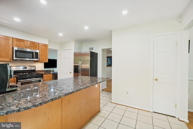 10104 Colebrook Ave, Potomac, MD 20854 - kitchen featuring stainless steel appliances, a peninsula, dark stone countertops, recessed lighting, and brown cabinetry
