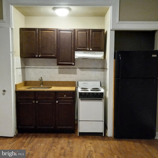 4623 N Broad St, Philadelphia, PA 19140 - kitchen with freestanding refrigerator, white range with electric cooktop, under cabinet range hood, a sink, and dark brown cabinetry