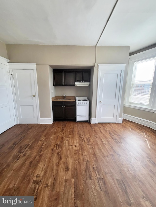 4623 N Broad St, Philadelphia, PA 19140 - kitchen with white electric stove, a sink, wood finished floors, baseboards, and under cabinet range hood