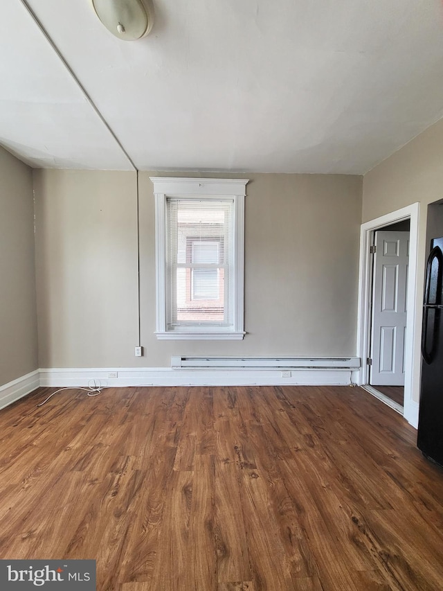 4623 N Broad St, Philadelphia, PA 19140 - spare room with wood finished floors, baseboards, and a baseboard heating unit