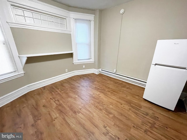 4623 N Broad St, Philadelphia, PA 19140 - unfurnished dining area with a baseboard heating unit, wood finished floors, and baseboards