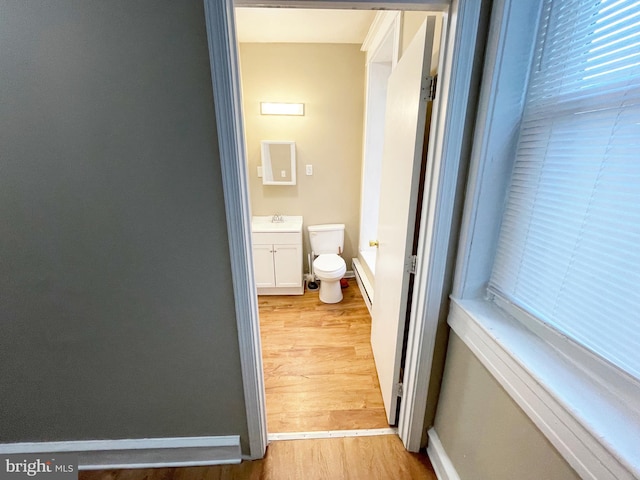 4623 N Broad St, Philadelphia, PA 19140 - bathroom with wood finished floors, toilet, vanity, baseboards, and a baseboard radiator