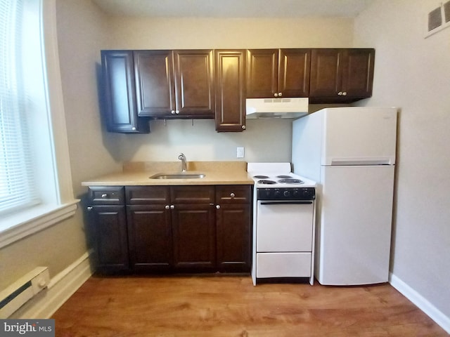 4623 N Broad St, Philadelphia, PA 19140 - kitchen with white appliances, under cabinet range hood, a sink, a baseboard heating unit, and light countertops