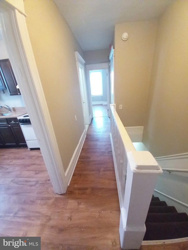 4623 N Broad St, Philadelphia, PA 19140 - hallway featuring wood finished floors, a sink, an upstairs landing, and baseboards