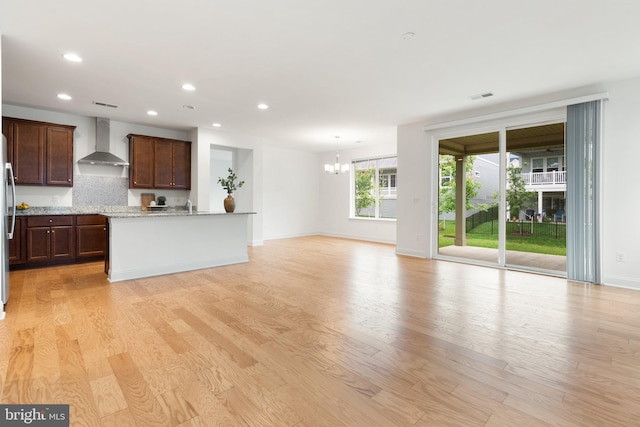 118 Milkweed Dr, Lake Frederick, VA 22630 - kitchen with wall chimney exhaust hood, a chandelier, light wood-style flooring, baseboards, and open floor plan