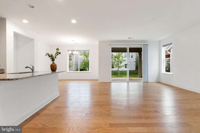 118 Milkweed Dr, Lake Frederick, VA 22630 - unfurnished living room with light wood-style flooring, baseboards, a chandelier, recessed lighting, and a sink