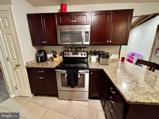 149 Smoketown Rd, Mertztown, PA 19539 - kitchen with appliances with stainless steel finishes, light stone countertops, a peninsula, light tile patterned floors, and dark brown cabinetry