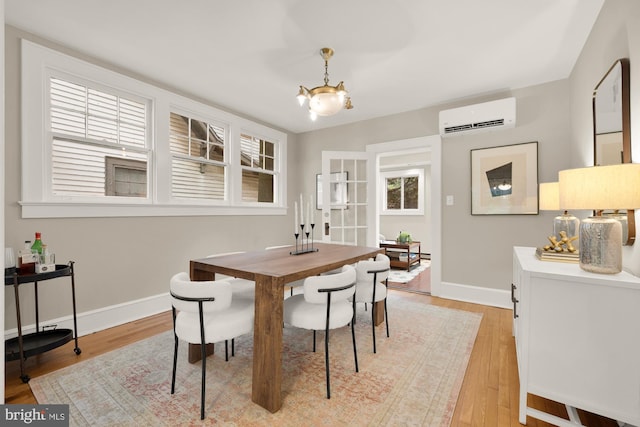 1505 Otis St NE, Washington, DC 20017 - dining area featuring a wall mounted AC, baseboards, light wood-style flooring, and a chandelier