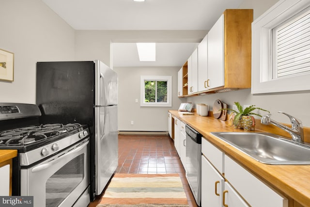 1505 Otis St NE, Washington, DC 20017 - kitchen featuring stainless steel appliances, a sink, baseboard heating, and white cabinetry