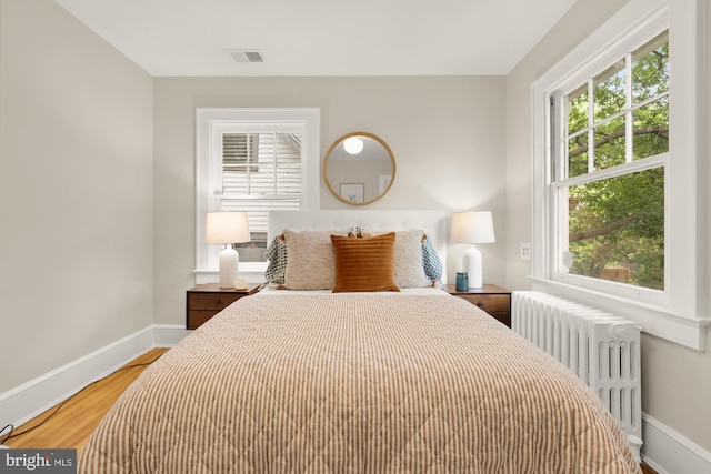 1505 Otis St NE, Washington, DC 20017 - bedroom with radiator heating unit, baseboards, multiple windows, and light wood-type flooring