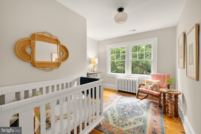 1505 Otis St NE, Washington, DC 20017 - bedroom with radiator heating unit, light wood-style floors, and baseboards