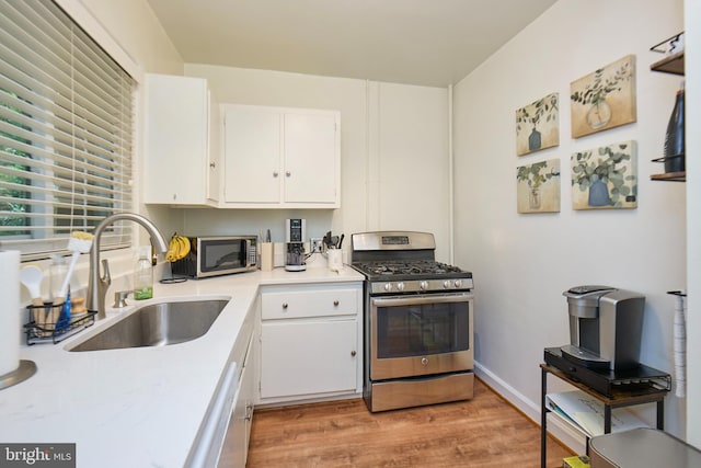 3501 Martha Custis Dr, Alexandria, VA 22302 - kitchen with appliances with stainless steel finishes, a sink, white cabinetry, light wood-style flooring, and light countertops
