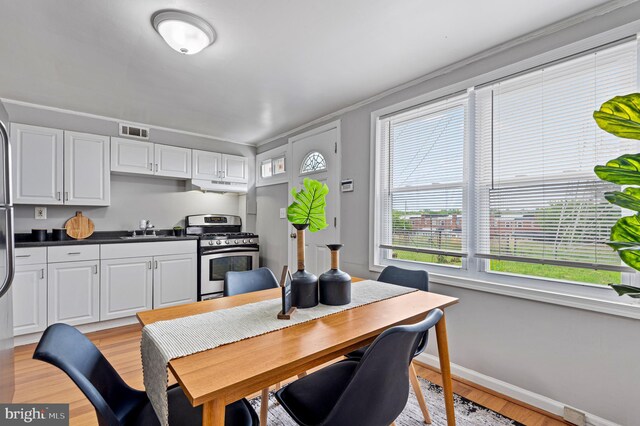 4937 Schaub Ave, Baltimore, MD 21206 - dining room with light wood-style flooring, baseboards, and ornamental molding