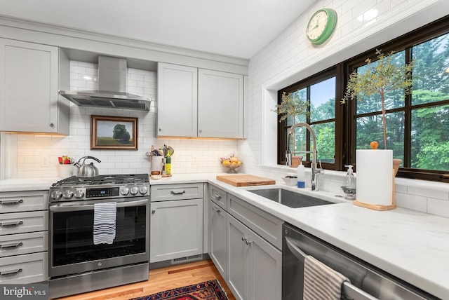 715 Morningside Dr, Towson, MD 21204 - kitchen with stainless steel appliances, wall chimney range hood, a sink, gray cabinets, and healthy amount of natural light