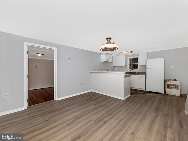 21 E D St, Brunswick, MD 21716 - kitchen with freestanding refrigerator, white cabinetry, a peninsula, wood finished floors, and baseboards