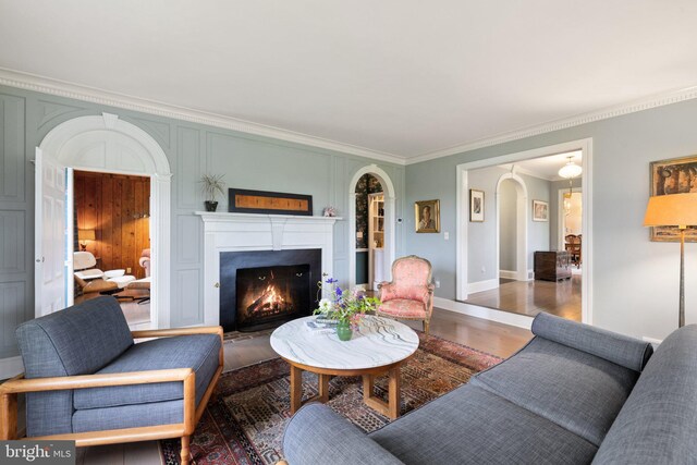 22693 St Louis Rd, Middleburg, VA 20117 - living room with arched walkways, crown molding, wood finished floors, a warm lit fireplace, and baseboards