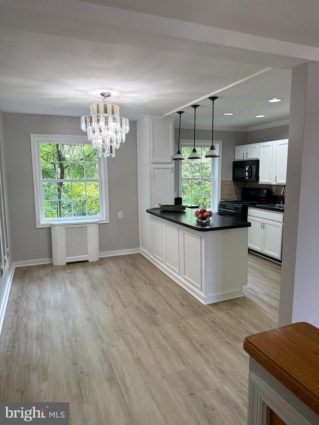 5104 Columbia Pike Unit 6, Arlington, VA 22204 - kitchen featuring black appliances, radiator heating unit, white cabinets, dark countertops, and a chandelier