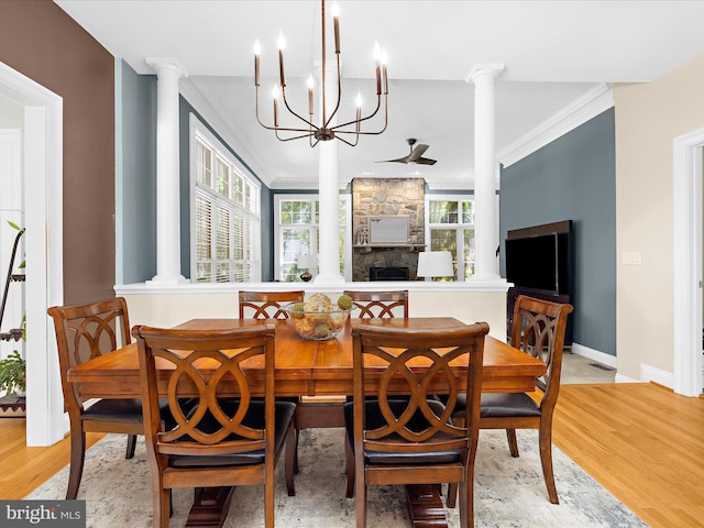 116 Colony Xing, Edgewater, MD 21037 - dining area featuring a ceiling fan, a stone fireplace, ornate columns, light wood-style flooring, and crown molding