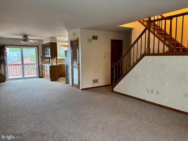 132 Popodickon Dr, Boyertown, PA 19512 - unfurnished living room featuring stairs, baseboards, light carpet, and ceiling fan