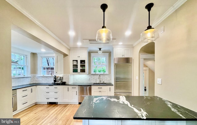 402 W Masonic View Ave, Alexandria, VA 22301 - kitchen featuring appliances with stainless steel finishes, white cabinets, light wood-style floors, decorative backsplash, and ornamental molding