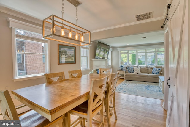 1606 Jeffers Rd, Baltimore, MD 21204 - dining room with light wood-type flooring, ornamental molding, and a barn door