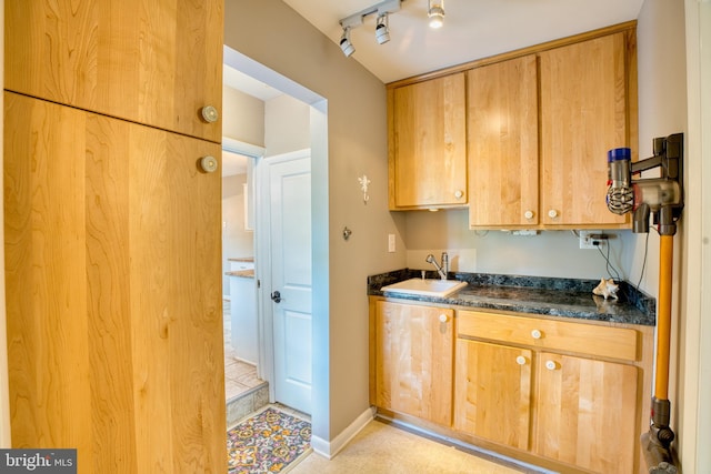 1606 Jeffers Rd, Baltimore, MD 21204 - kitchen with dark countertops, a sink, track lighting, and baseboards
