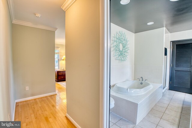 1606 Jeffers Rd, Baltimore, MD 21204 - bathroom with ornamental molding, a bath, toilet, baseboards, and hardwood / wood-style flooring